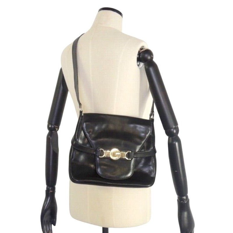 1970s Gucci saddle bag in black leather with muted gold hardware, an expandable bottom, wide shoulder strap, and burgundy leather lining | AlmaBagz - Image 4